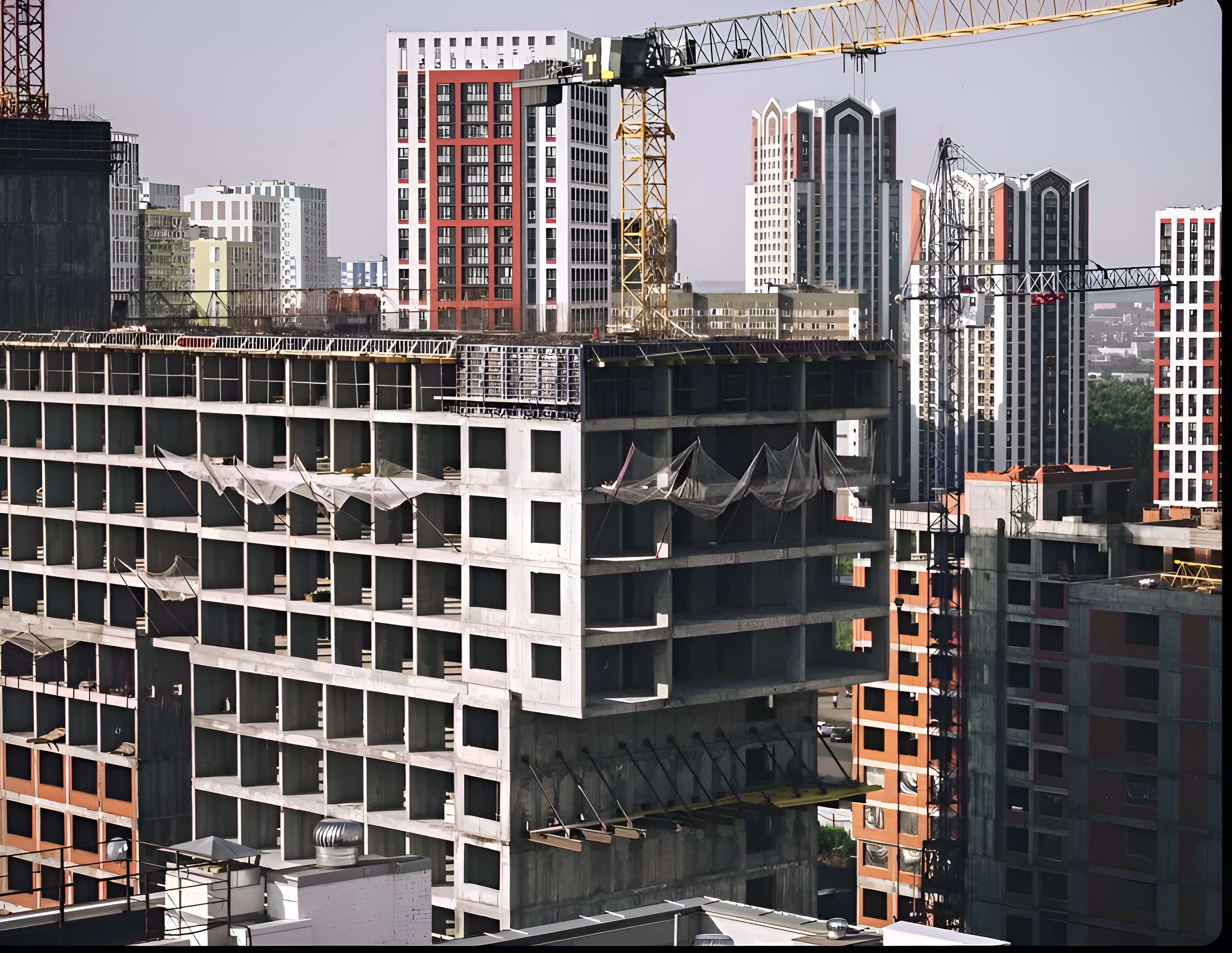 Concrete frame of a high-rise under construction with tower cranes