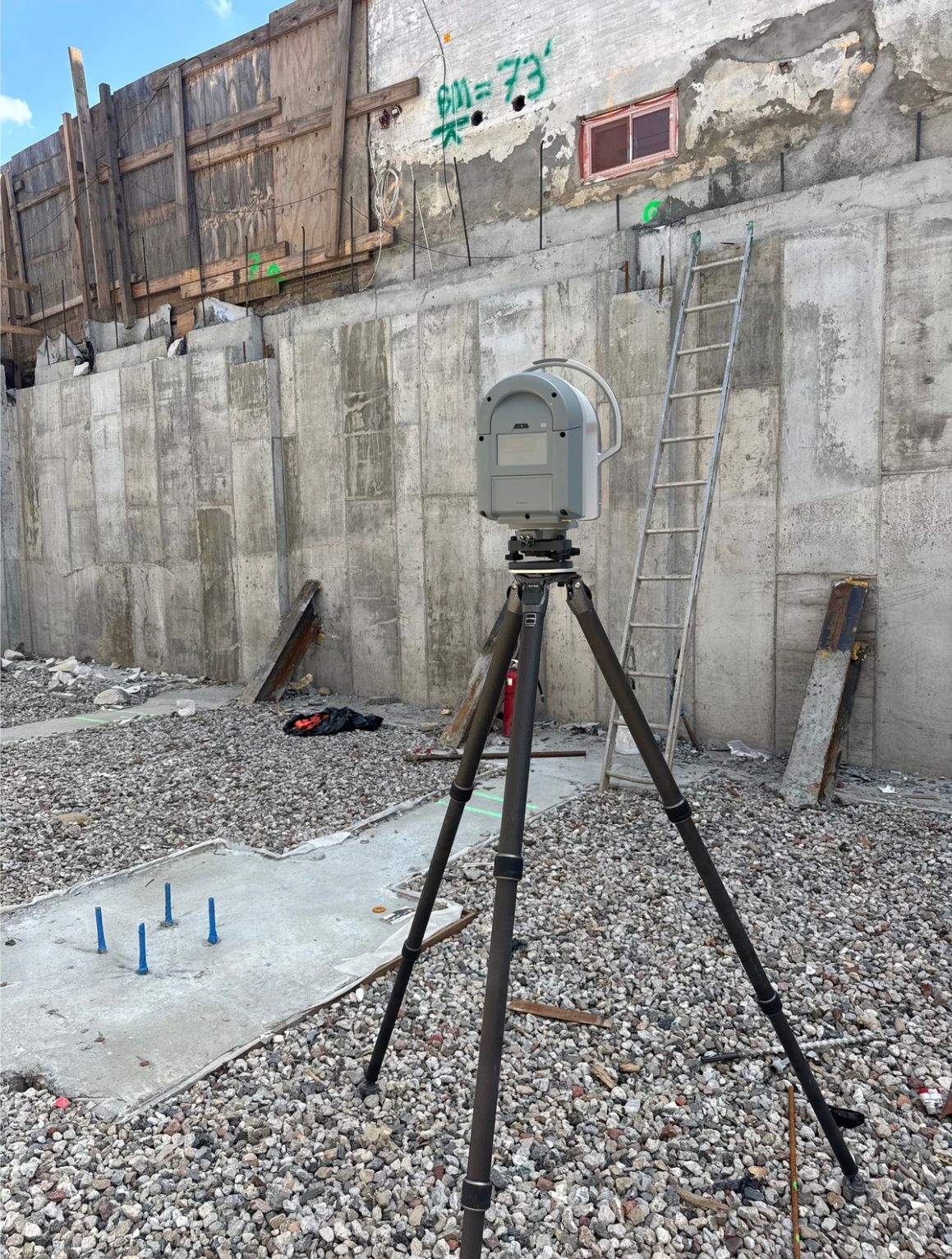 Laser scanner on a tripod documenting a foundation wall at a New York construction site